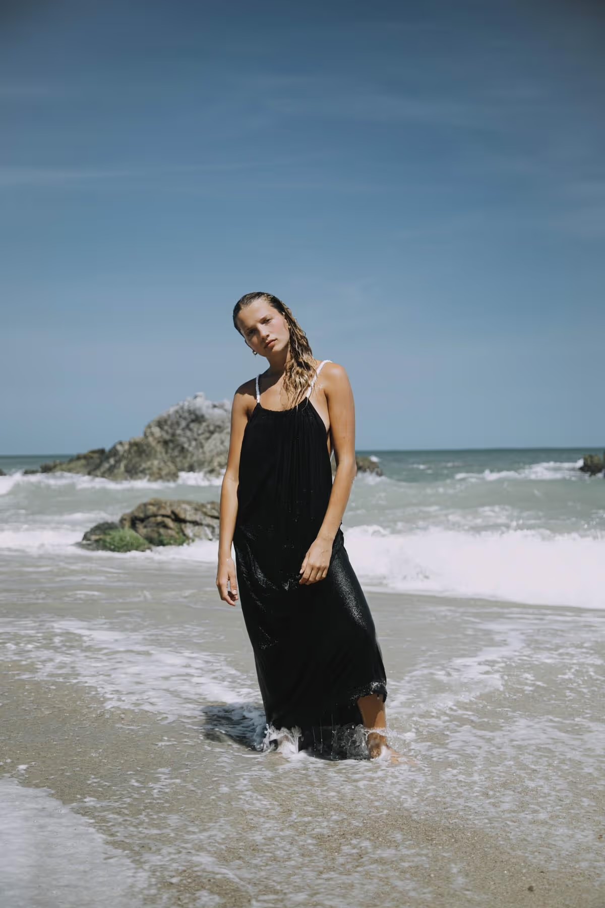 A guest standing in the shallow surf at Casa Sal