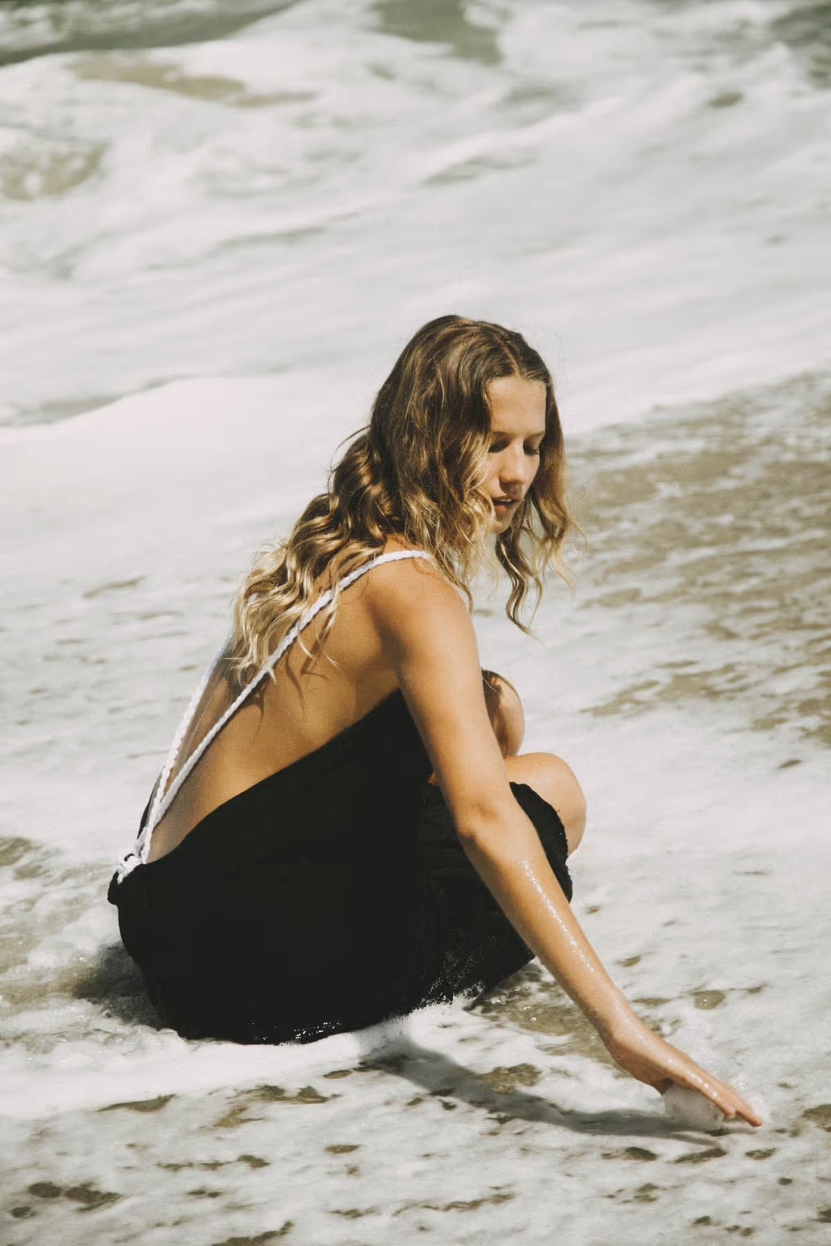 A guest resting in the foam at the water's edge